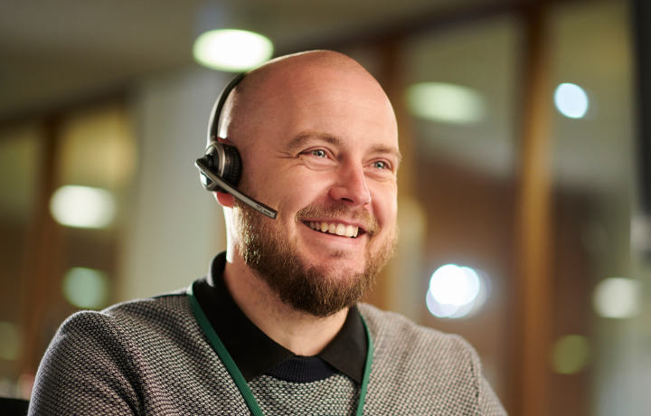 Glad man med headset, redo svara i telefon