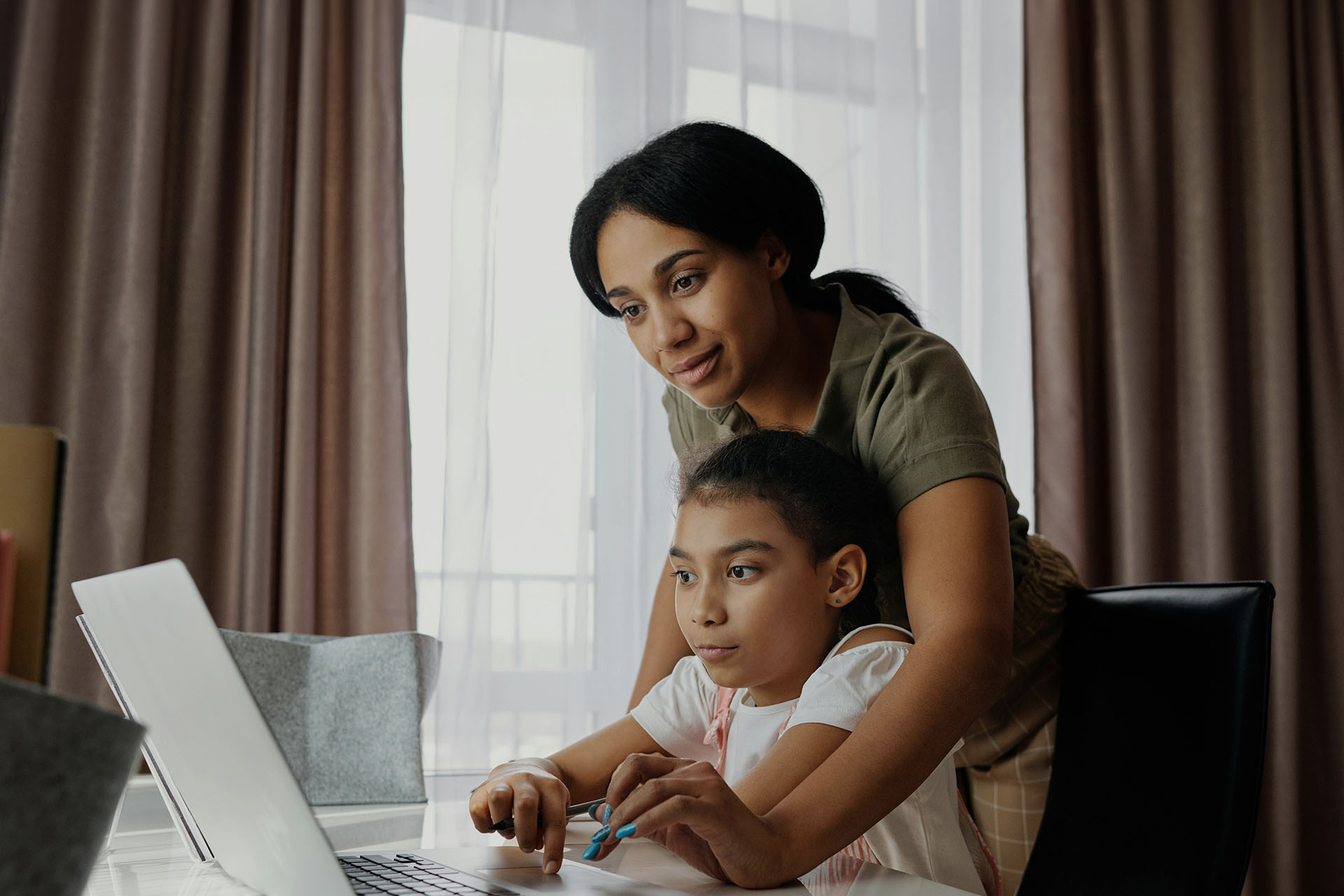 en mamma hjälper dotter med laptop