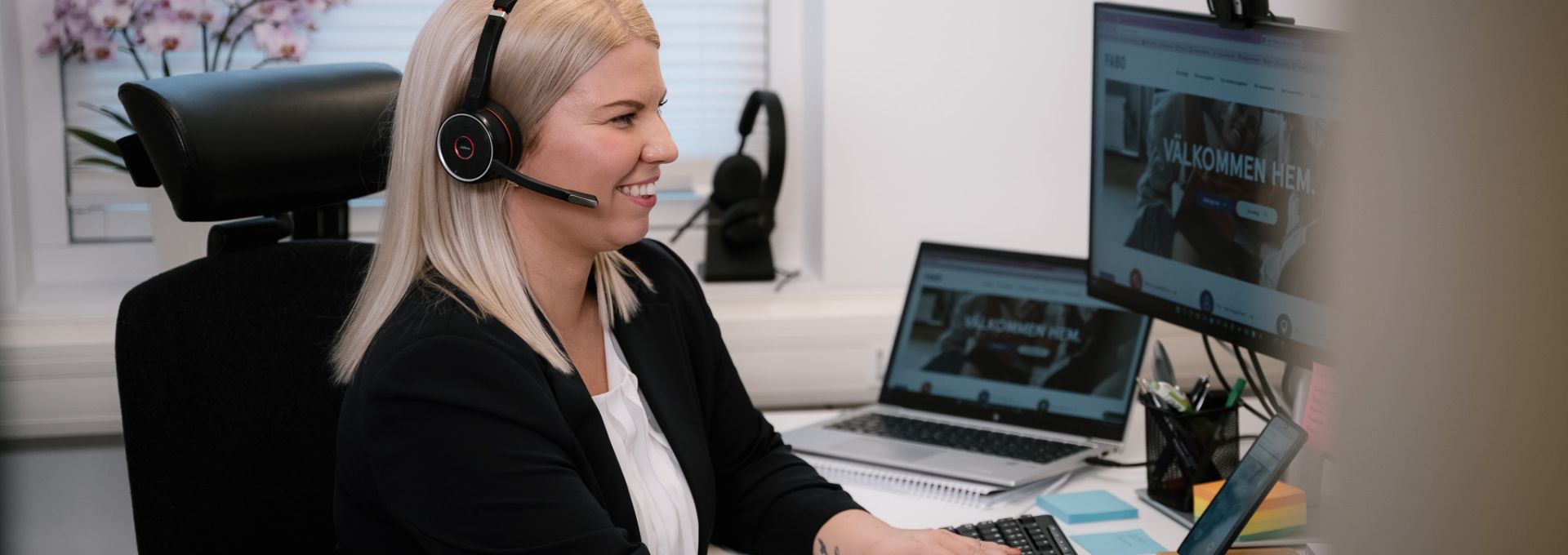 Kvinna framför datorskärm med headset på