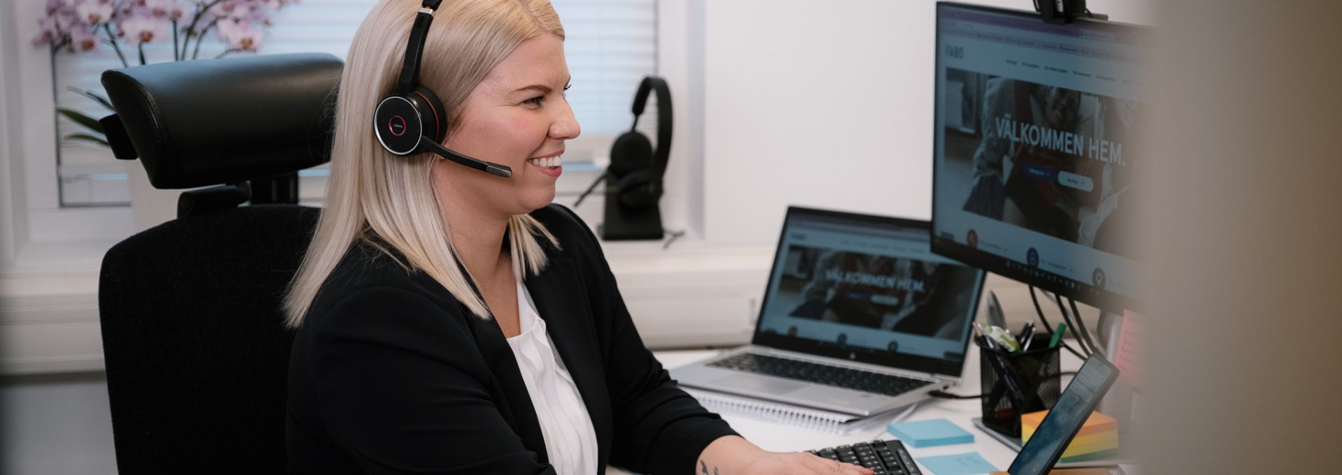 Kvinna framför datorskärm med headset på