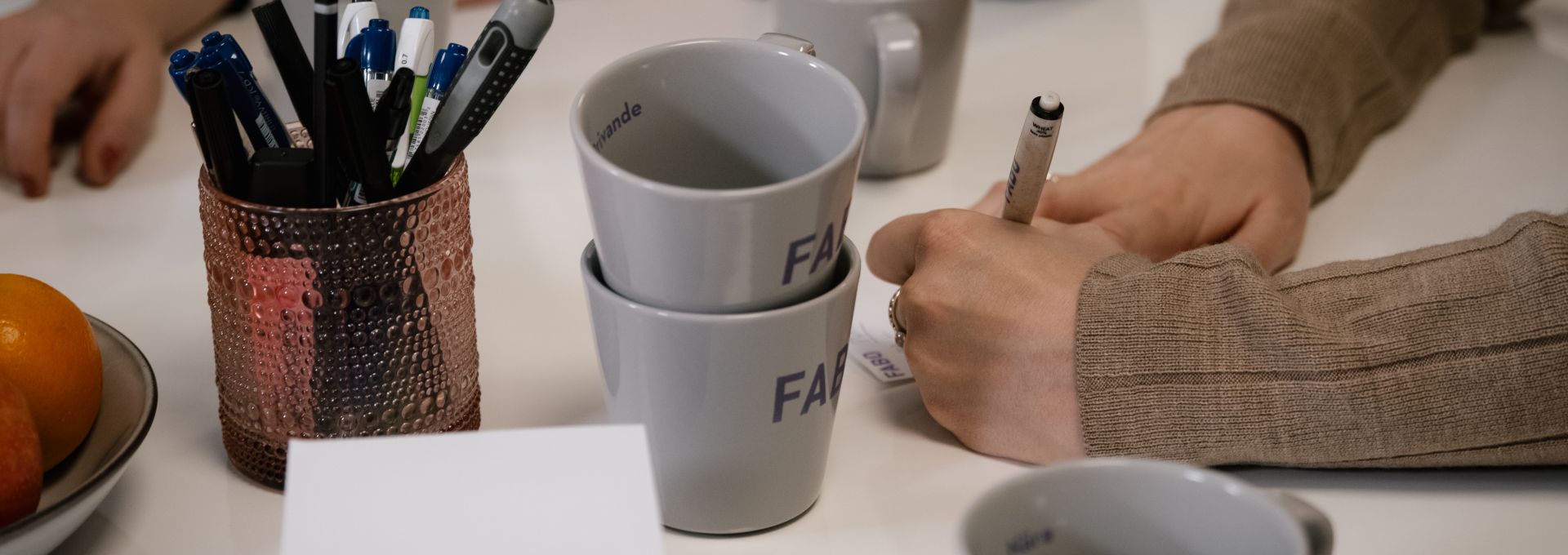 Ett bord med muggar, papper, block