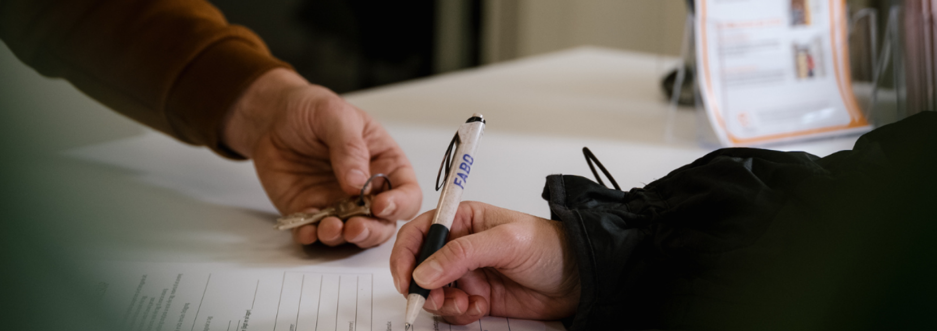 Två personer, vars händer bara syns över ett papper - den ena skriver under ett kontrakt