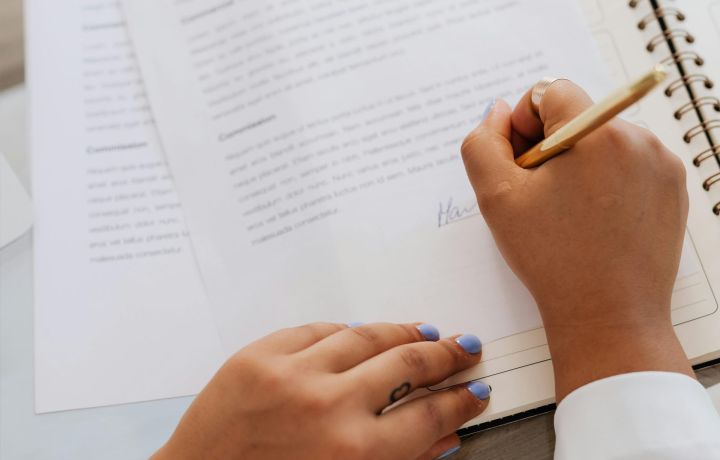 en hand signerar ett dokument