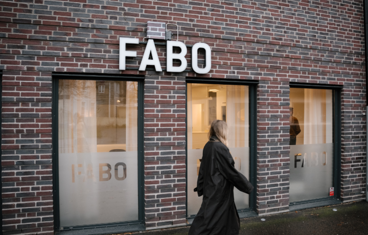 Fabos husfasad, kvinna går framför huset på trottoaren