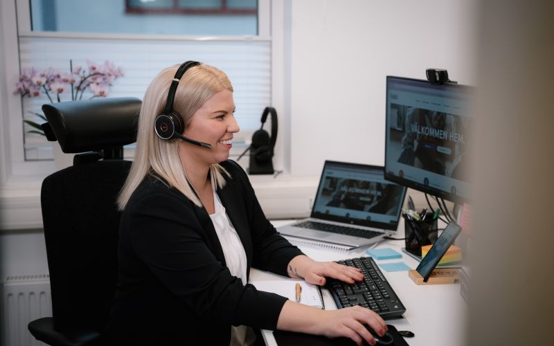 Kvinna framför datorskärm med headset på