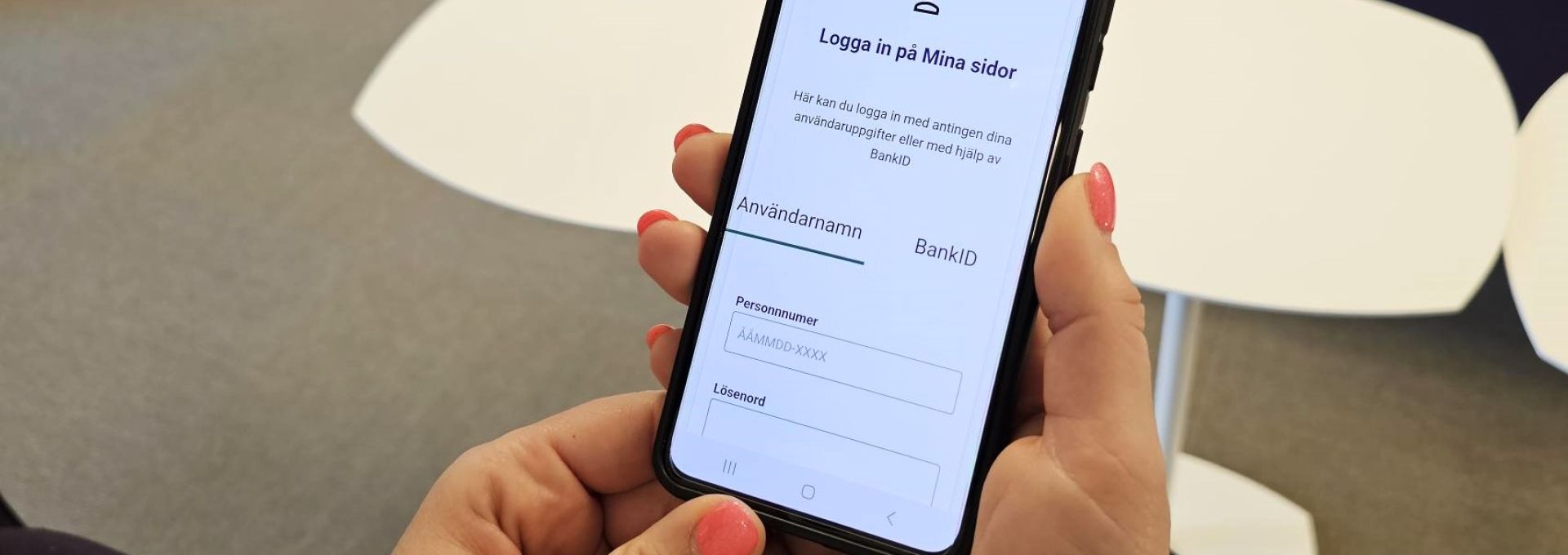Person som håller mobil i handen men Mina sidor på