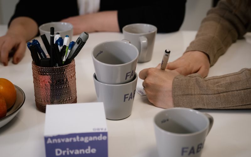 Ett bord med muggar, papper, block